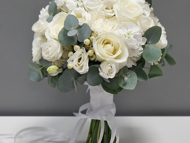 Bride's bouquet of white roses, eustoma, dianthus, mathiola, hypericum, and eucalyptus photo